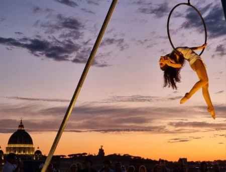 Un'acrobata sul cerchio al tramonto con San Pietro sullo sfondo