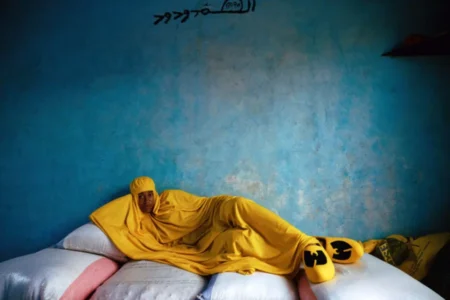Una donna vestita di giallo adagiata su un materasso